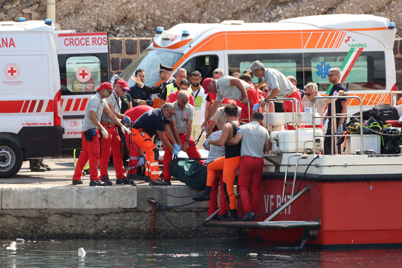 © Reuters. Emergency services carry a body bag after a sailboat sank in the early hours of Monday, off the coast of Porticello, near the Sicilian city of Palermo, Italy, August 19, 2024. REUTERS/Igor Petyx