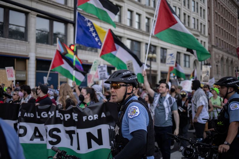 &copy; Reuters. FILE PHOTO: Police officers stand near marching activists as they wave Palestinian flags ahead of the Democratic National Convention (DNC), in Chicago, Illinois, U.S., August 18, 2024.  REUTERS/Adrees Latif/File Photo