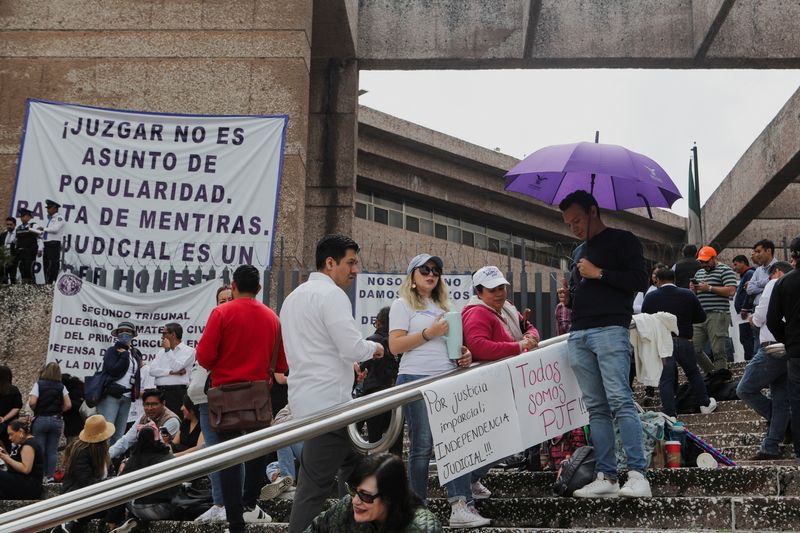 © Reuters. People stand outside the building of the Federal Judiciary Council as Mexico's judicial workers launched an indefinite nationwide strike ahead of votes by lawmakers on overhauling the country's judiciary, including moving to the popular election of judges, in Mexico City, Mexico August 19, 2024. REUTERS/Paola Garcia