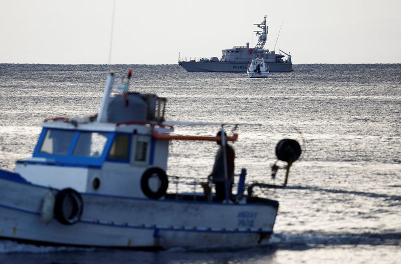 © Reuters. A fishing boat sails past a finance police vessel and a coast guard vessel operating in the sea to search for the missing, including British entrepreneur Mike Lynch, after a luxury yacht sank off the coast of Porticello, near the Sicilian city of Palermo, Italy, August 20, 2024. REUTERS/Guglielmo Mangiapane