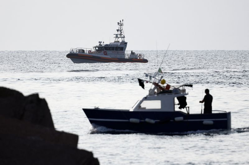 © Reuters. A fishing boat sails past a coast guard vessel operating in the sea to search for the missing, including British entrepreneur Mike Lynch, after a luxury yacht sank off the coast of Porticello, near the Sicilian city of Palermo, Italy, August 20, 2024. REUTERS/Guglielmo Mangiapane