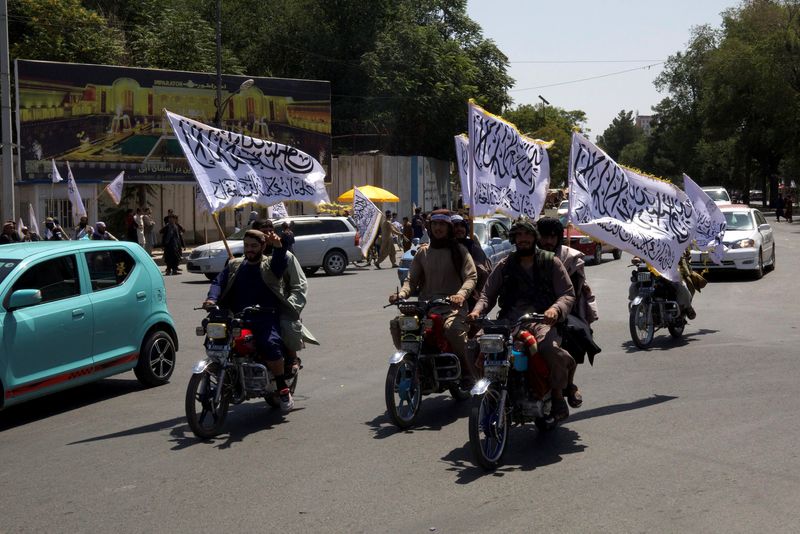 © Reuters. FILE PHOTO: Members of the Taliban carrying flags ride motorbikes as they participate in a rally to mark the third anniversary of the fall of Kabul, in Kabul, Afghanistan, August 14, 2024. REUTERS/Sayed Hassib/File Photo