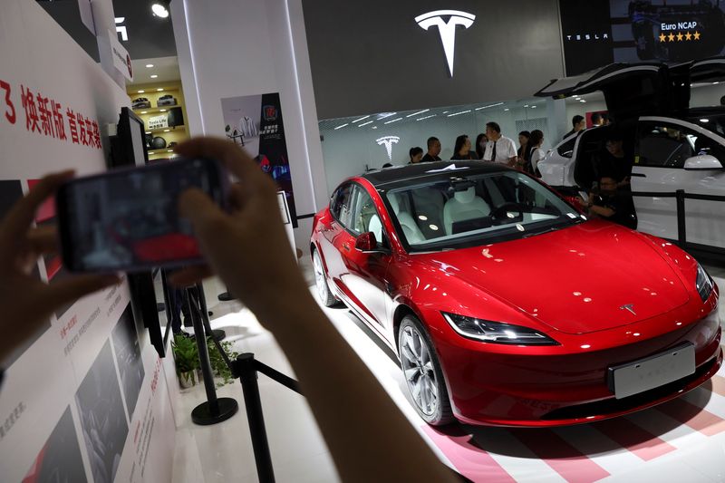 © Reuters. FILE PHOTO: A visitor takes pictures of Tesla's Model 3 sedan displayed at the China International Fair for Trade in Services (CIFTIS) in Beijing, China September 2, 2023. REUTERS/Florence Lo