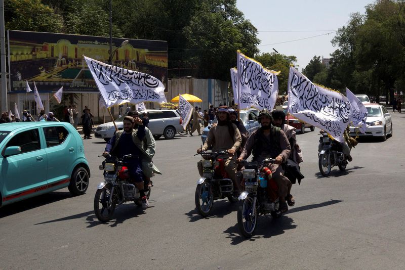 &copy; Reuters. Membros do Taliban carregam bandeiras em motos enquanto participam de comício para marcar o terceiro aniversário da queda de Cabul, Afeganistãon14/08/2024nREUTERS/Sayed Hassib