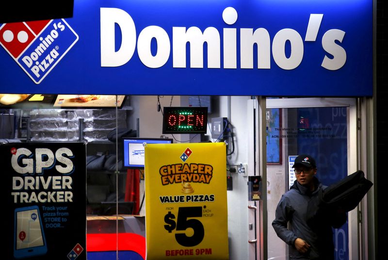 © Reuters. FILE PHOTO: A worker carries a pizza for delivery as he leaves a Domino's pizza shop in Sydney, Australia August 12, 2015. REUTERS/David Gray/File Photo