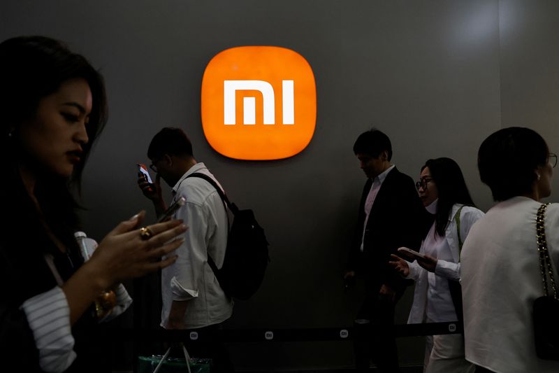 &copy; Reuters. FILE PHOTO: Visitors walk past a Xiaomi logo at the Beijing International Automotive Exhibition, or Auto China 2024, in Beijing, China, April 25, 2024. REUTERS/Tingshu Wang/File Photo