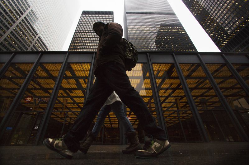 © Reuters. A man walks in front of buildings in the financial district in Toronto, January 28, 2013.   REUTERS/Mark Blinch/ File Photo