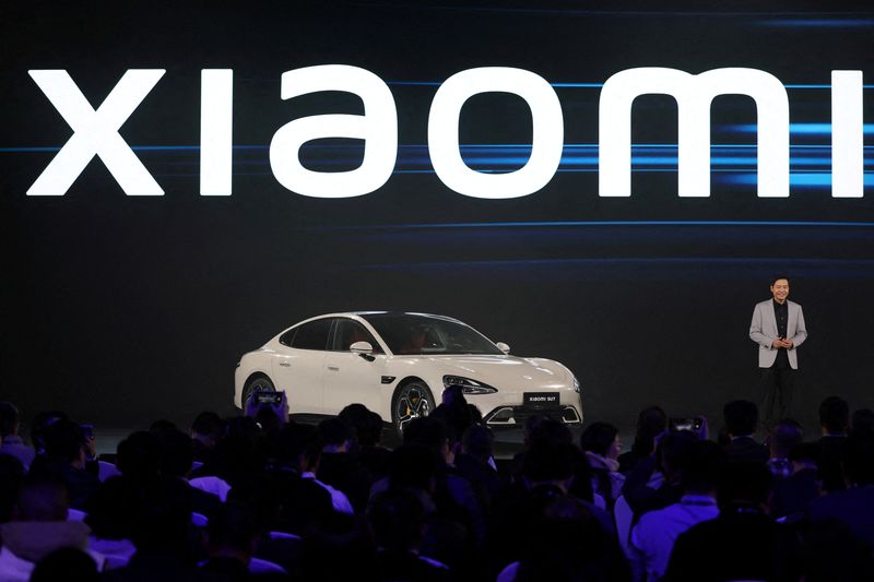 © Reuters. FILE PHOTO: Xiaomi founder and CEO Lei Jun stands next to Xiaomi's newly unveiled first electric vehicle (EV) SU7, at an event in Beijing, China December 28, 2023. REUTERS/Florence Lo/File Photo