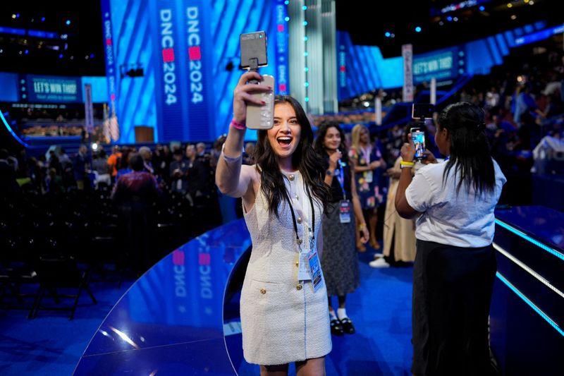 © Reuters. FILE PHOTO: An influencer uses a phone at the United Center, ahead of the Democratic National Convention (DNC), in Chicago, Illinois, U.S., August 19, 2024. REUTERS/Cheney Orr/File Photo