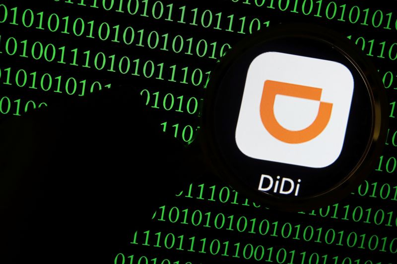 © Reuters. FILE PHOTO: The app logo of Chinese ride-hailing giant Didi is seen through a magnifying glass on a computer screen showing binary digits in this illustration picture taken July 7, 2021. REUTERS/Florence Lo/Illustration/File Photo