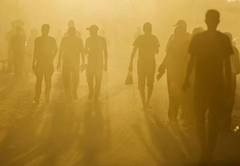 &copy; Reuters. Palestinians walk in an area damaged during the Israeli offensive, amid the ongoing conflict between Israel and Hamas, in Khan Younis, in the southern Gaza Strip August 20, 2024. REUTERS/Mohammed Salem