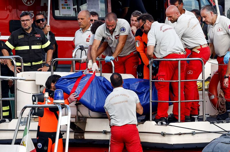 © Reuters. Rescue personnel transport a body bag after a luxury yacht, which was carrying British entrepreneur Mike Lynch, sank off the coast of Porticello, near the Sicilian city of Palermo, Italy, August 21, 2024. REUTERS/Guglielmo Mangiapane