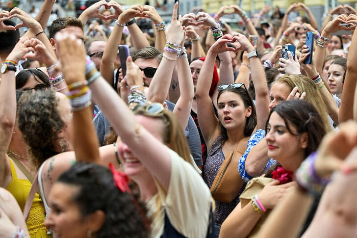 © Reuters. Fans of the singer Taylor Swift make a heart shape with their hands as they gather following the cancellation of three Taylor Swift concerts at Happel stadium after the government confirmed a planned attack at the venue, in Vienna, Austria August 8, 2024. REUTERS/Elisabeth Mandl/files