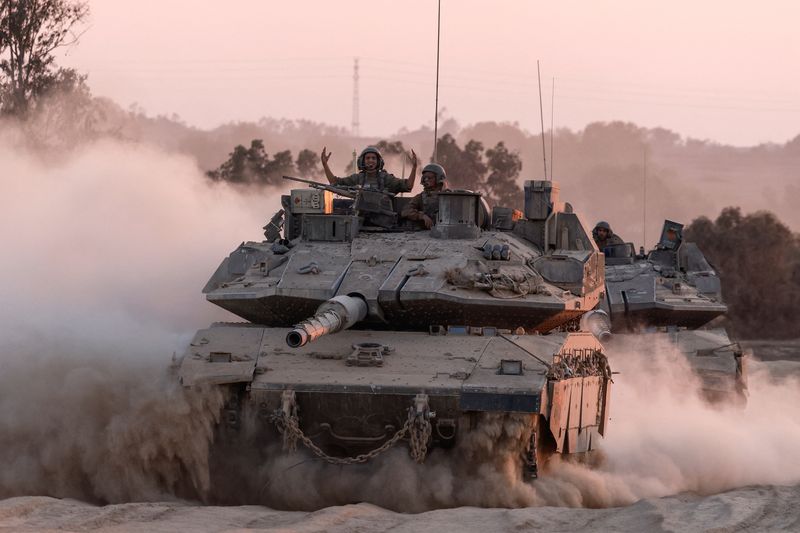 © Reuters. An Israeli soldier gestures on a top of a tank as Israeli military vehicles manoeuvre, near the Israel-Gaza border, amid the Israel-Hamas conflict, August 21, 2024. REUTERS/Amir Cohen