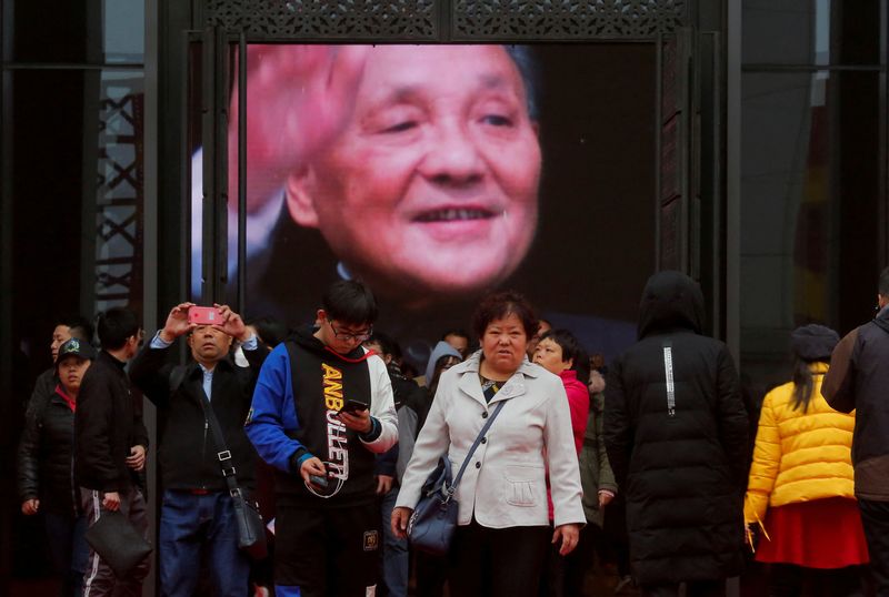 © Reuters. FILE PHOTO: Visitors stand in front of a screen showing late Chinese leader Deng Xiaoping at an exhibition marking the 40th anniversary of China's reform and opening-up at the National Museum of China in Beijing, China November 14, 2018. REUTERS/Thomas Peter/File Photo