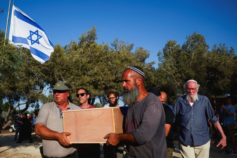 © Reuters. Mourners carry the coffin of Yoram Metzger, one of the six hostages whose bodies were retrieved from Gazan captivity and brought to Israel in a military operation, at his funeral in Kibbutz Nir Oz, southern Israel, August 22, 2024. REUTERS/Florion Goga