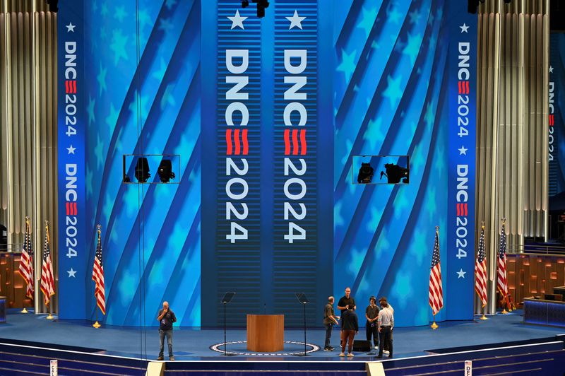 © Reuters. Workers make adjustments on stage at the United Center, the host venue of the Democratic National Convention (DNC) in Chicago, Illinois, U.S. August 18, 2024 REUTERS/Vincent Alban