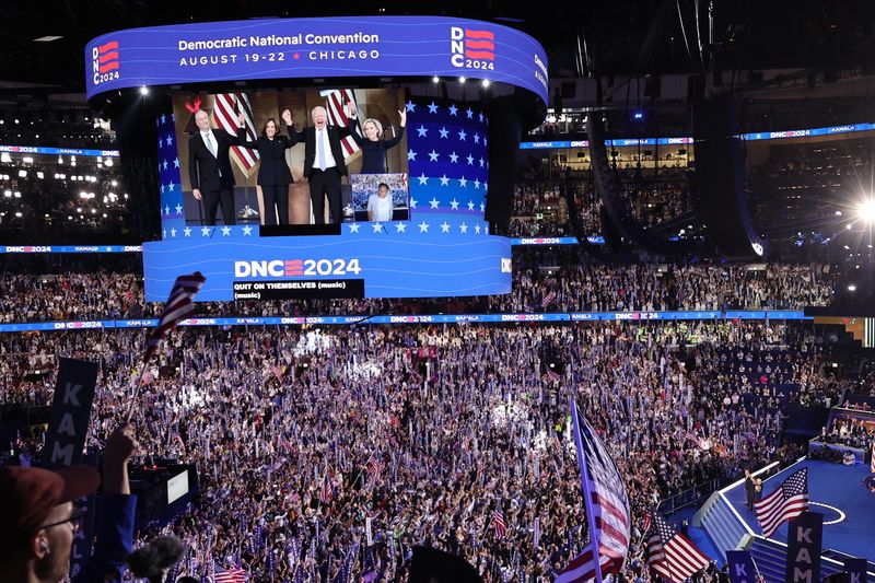 &copy; Reuters. Democratic presidential nominee and U.S. Vice President Kamala Harris stands with her husband Doug Emhoff, U.S. Democratic vice presidential nominee Minnesota Governor Tim Walz and his wife Gwen on Day 4 of the Democratic National Convention (DNC) at the 