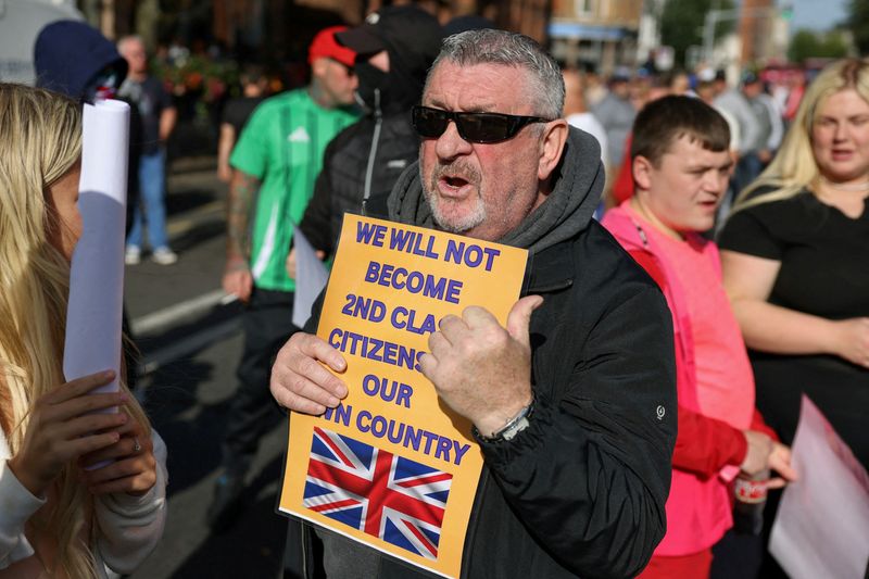 © Reuters. FILE PHOTO: Protesters attend an anti-immigration protest in Belfast, Northern Ireland, August 9, 2024. REUTERS/Hollie Adams/File Photo