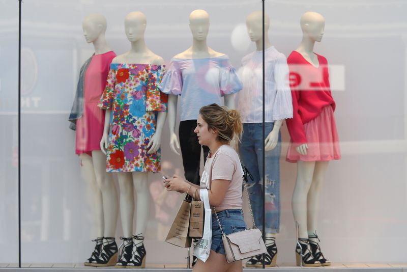 © Reuters. A woman carries shopping bags while walking past a window display outside a retail store in Ottawa, Ontario, Canada, July 21, 2017. REUTERS/Chris Wattie/File Photo