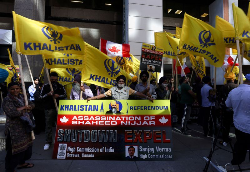 © Reuters. FILE PHOTO: A group of protesters hold yellow flags with the word Khalistan, as well as a banner with the picture of Sikh separatist leader Hardeep Singh, during a protest outside India's consulate, a week after Canada's Prime Minister Justin Trudeau raised the prospect of New Delhi's involvement in the murder of Sikh separatist leader Hardeep Singh Nijjar in British Columbia, in Toronto, Ontario, Canada September 25, 2023. REUTERS/Carlos Osorio/File Photo