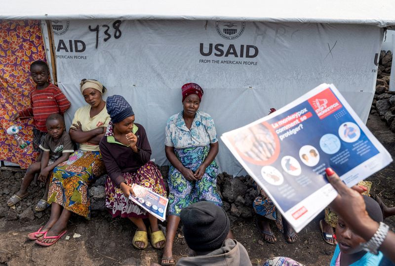 © Reuters. FILE PHOTO: Internally displaced women listen to Nathalie Kipenzi, a hygiene promoter, during an awareness campaign for Mpox, an infectious disease caused by the Mpox virus that causes a painful rash, enlarged lymph nodes and fever, at the Muja camp for the internally displaced in Nyiragongo territory, near Goma in North Kivu province of the Democratic Republic of Congo August 19, 2024. REUTERS/Arlette Bashizi/File Photo