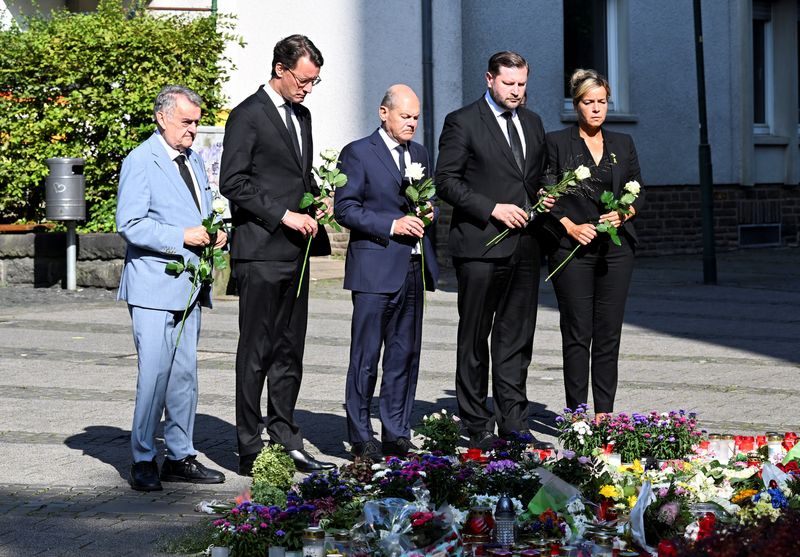 © Reuters. North Rhine-Westphalia state premier Hendrik Wuest, Solingen mayor Tim Kurzbach and German Chancellor Olaf Scholz pay their respects at the site where three people were killed and several injured in a stabbing attack at a festival, in Solingen, Germany, August 26, 2024. REUTERS/Jana Rodenbusch