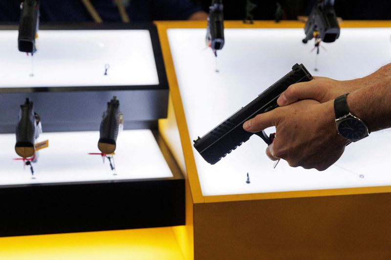 © Reuters. FILE PHOTO: A person tries out a handgun during the annual National Rifle Association (NRA) meeting in Dallas, Texas, U.S., May 17, 2024. REUTERS/Shelby Tauber/File Photo