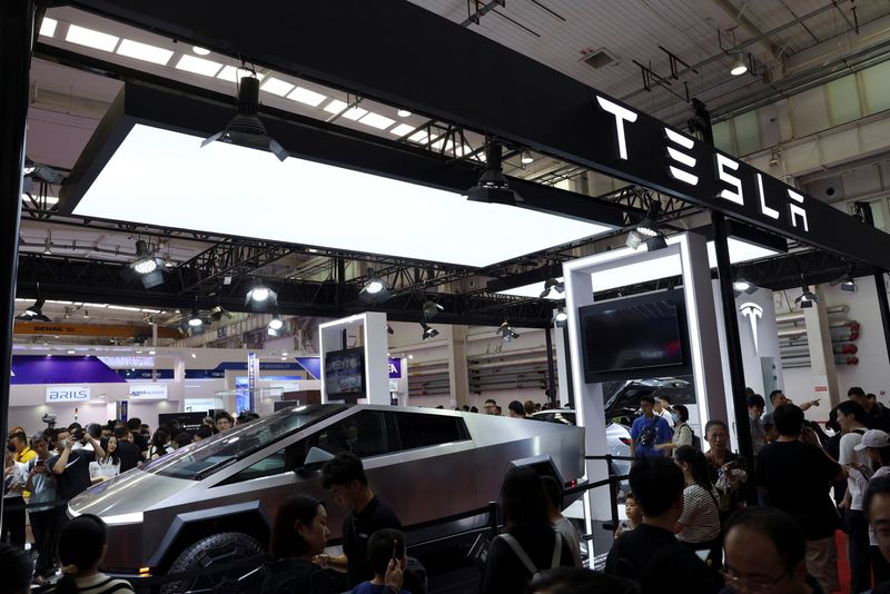 © Reuters. FILE PHOTO: Visitors walk past Tesla's Cybertruck displayed at the World Robot Conference in Beijing, China August 21, 2024. REUTERS/Florence Lo/File Photo