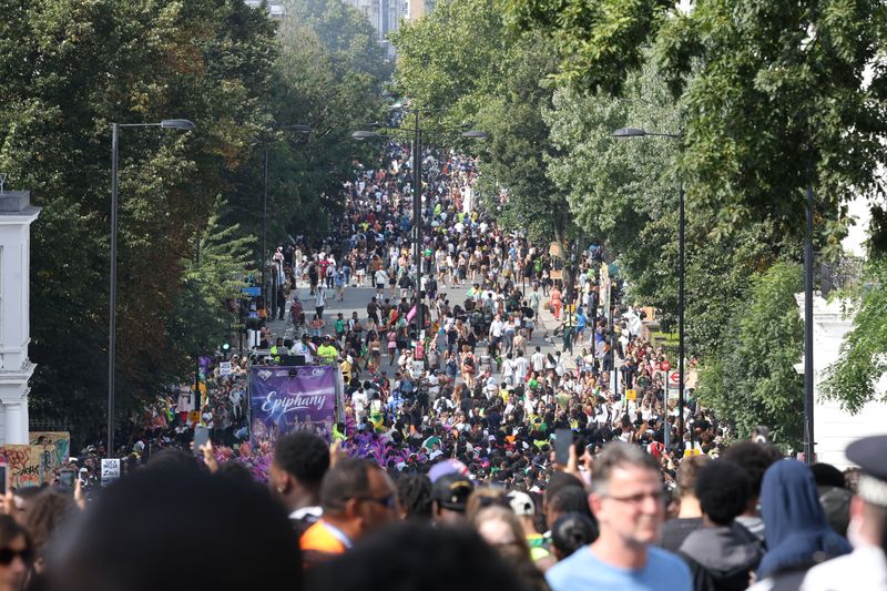 &copy; Reuters. Pessoas caminham na rua Ladbroke Grove durante o Carnaval de Notting Hill, em Londres, Reino Unidon26/08/2024nREUTERS/Mina Kim