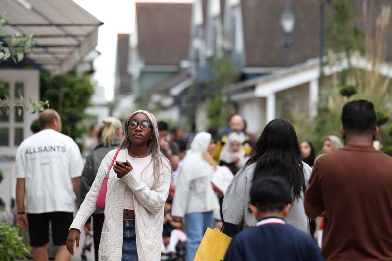 © Reuters. FILE PHOTO: Shoppers walk past designer outlet retail stores at Bicester Village in Oxfordshire, Britain, August 21, 2024. REUTERS/Hollie Adams/File Photo