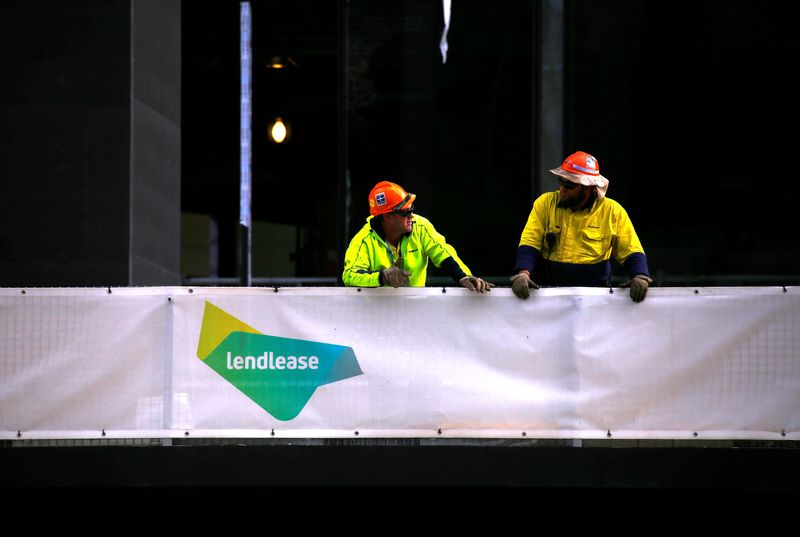 © Reuters. Construction workers lean on a fence adorned with a sign for the construction company Lendlease at a construction site in central Sydney, Australia, June 1, 2016.     REUTERS/David Gray/File Photo