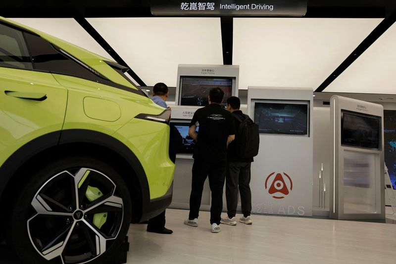 © Reuters. FILE PHOTO: Visitors look at screens that demonstrate Huawei's intelligent driving software Qiankun, at its booth during the Beijing International Automotive Exhibition, or Auto China 2024, in Beijing, China, April 25, 2024. REUTERS/Tingshu Wang/File Photo