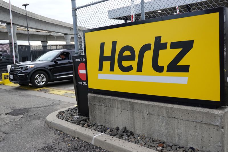 &copy; Reuters. FILE PHOTO: A car exits a lot and passes by Hertz rental car signage at John F. Kennedy International Airport in Queens, New York City, U.S., March 30, 2022. REUTERS/Andrew Kelly/File Photo