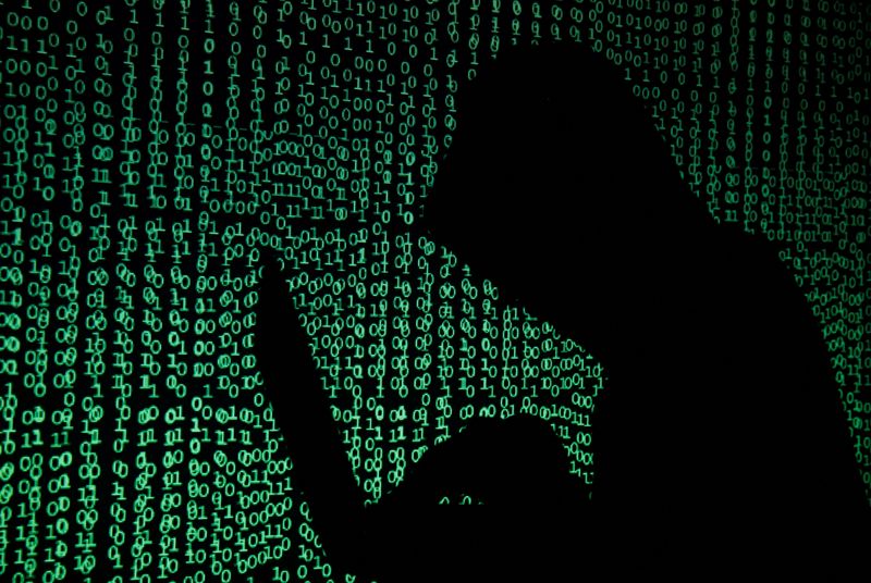 © Reuters. File Photo: In this illustrated photo taken on May 13, 2017, a hooded man holds a laptop with cyber code projected onto it. REUTERS/Kakuper Pempel/Illustration/File Photo