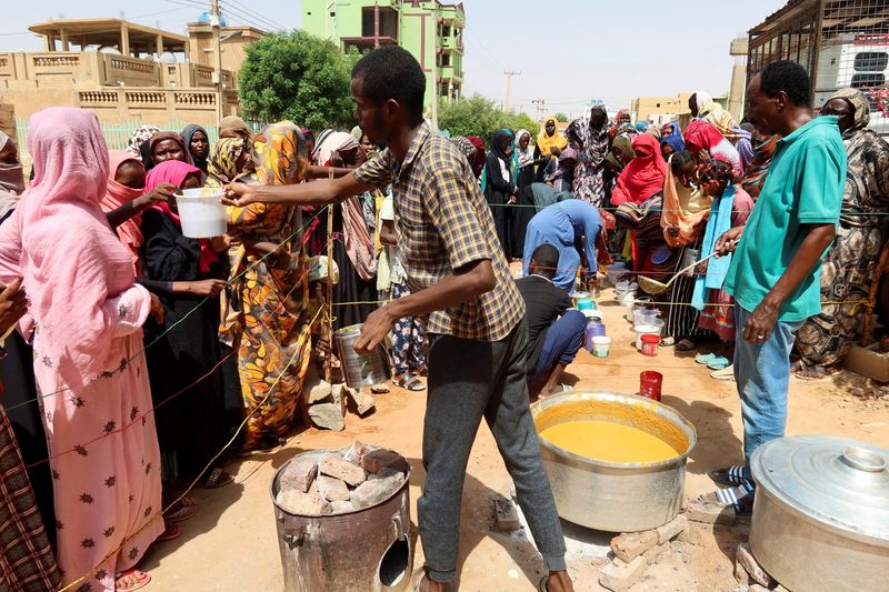 © Reuters. FILE PHOTO: A volunteer distributes food to people in Omdurman, Sudan, September 3, 2023. REUTERS/El Tayeb Siddig/File Photo