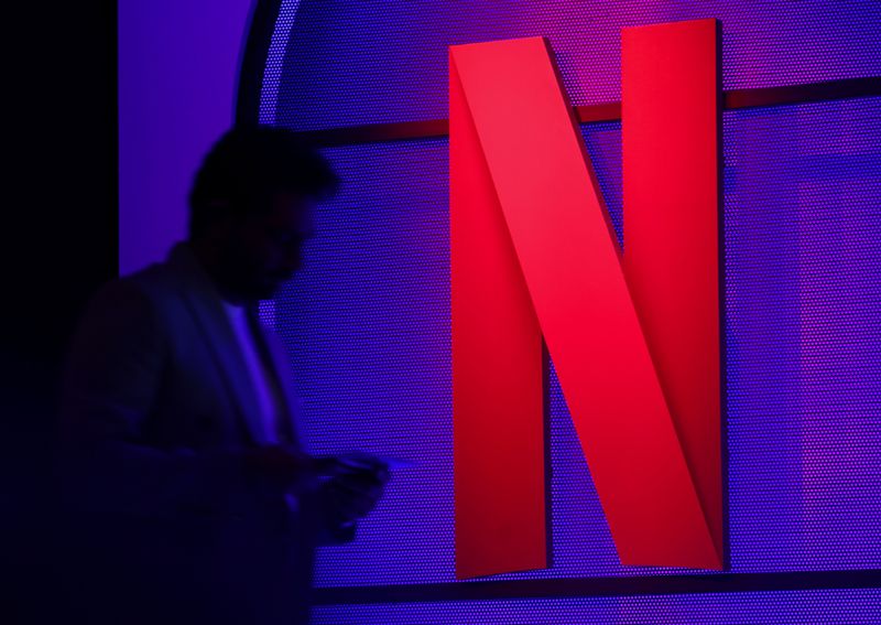 &copy; Reuters. FILE PHOTO: A man stands next to a logo of Netflix during an event in Mumbai, India, February 29, 2024. REUTERS/Francis Mascarenhas/File Photo