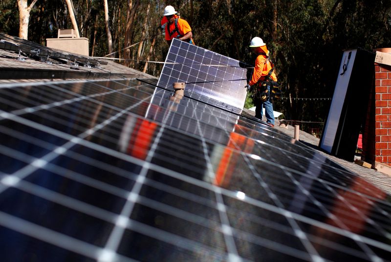 © Reuters. FILE PHOTO: Baker Electric solar installers place solar panels on the roof of a residential home in Scripps Ranch, San Diego, California, U.S., October 14, 2016. REUTERS/Mike Blake/File Photo