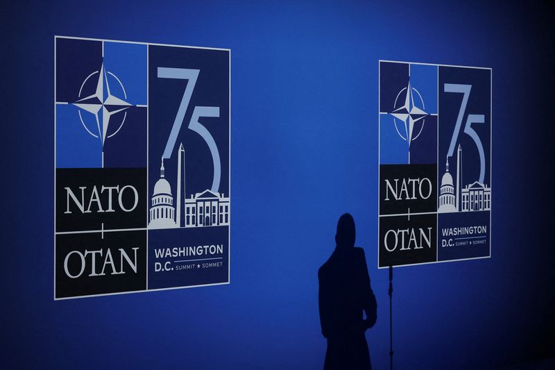 © Reuters. FILE PHOTO: A journalist casts a shadow next to logos on the day of the NATO 75th Anniversary celebratory event in Washington, U.S., July 9, 2024. REUTERS/Yves Herman/File Photo