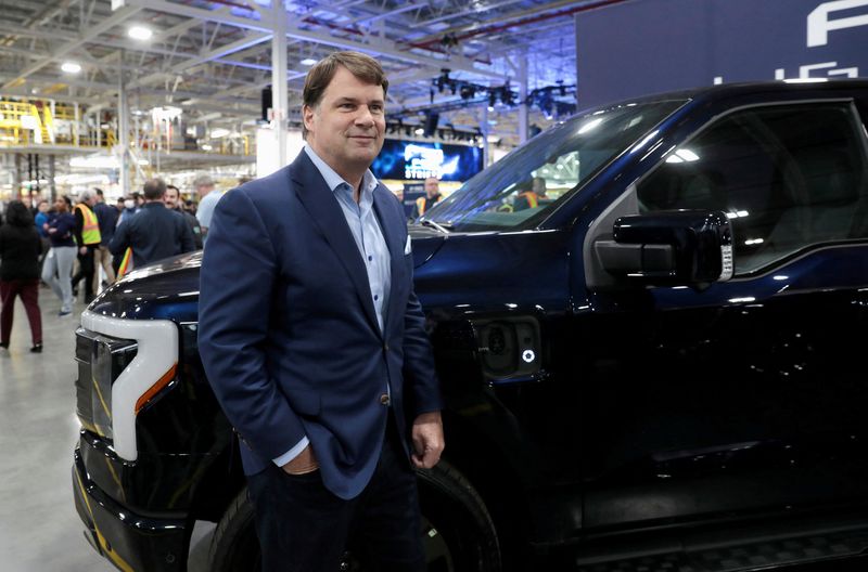 © Reuters. FILE PHOTO: Ford CEO Jim Farley poses next to a model of the Ford F-150 Lightning electric pickup truck at the Ford Rouge Electric Vehicle Center in Dearborn, Michigan, U.S. April 26, 2022. REUTERS/Rebecca Cook/File Photo