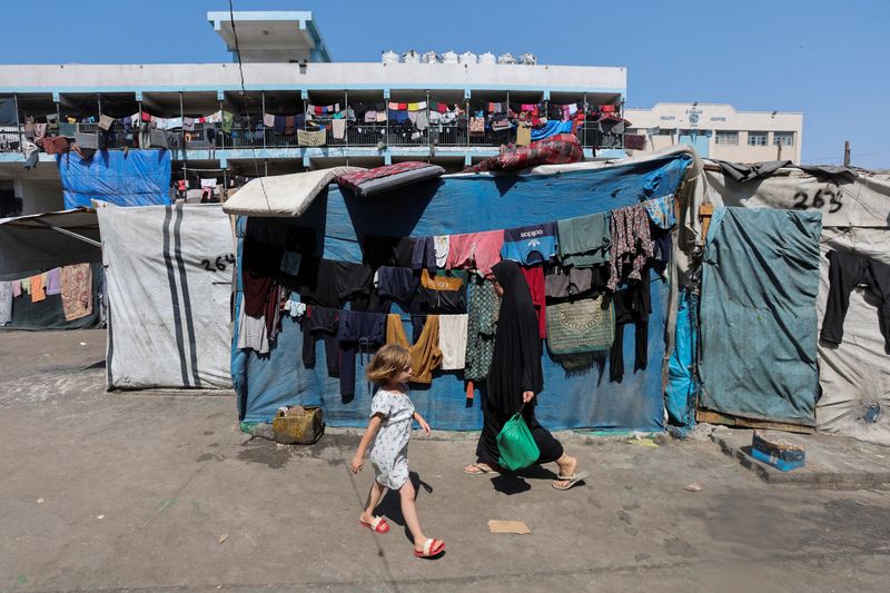 © Reuters. FILE PHOTO: Displaced Palestinians shelter in a United Nations-run school, amid Israel-Hamas conflict, in Deir Al-Balah in the central Gaza Strip, August 27, 2024. REUTERS/Ramadan Abed/File Photo