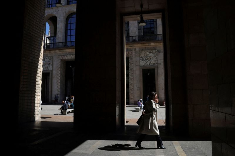 © Reuters. FILE PHOTO: A woman walks under the Palazzo dell'Arengario, in Milan, Italy, March 25, 2024. REUTERS/Claudia Greco/File Photo