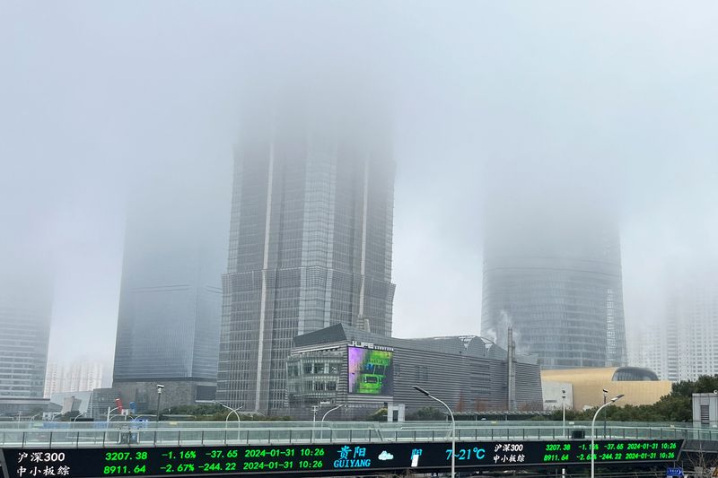 © Reuters. FILE PHOTO: A display of stock information is seen in front of buildings in Lujiazui financial district that are shrouded in fog amid an orange alert for heavy fog in Shanghai, China January 31, 2024. REUTERS/Xihao Jiang/File Photo