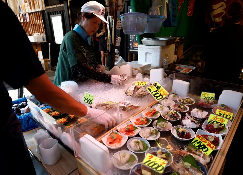 © Reuters. FILE PHOTO: Vendors prepare seafood for sale at Tsukiji Outer Market in Tokyo, Japan, August 12, 2024. REUTERS/Willy Kurniawan/File Photo