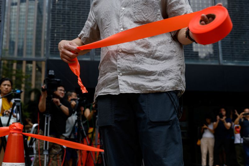 © Reuters. A police holds a cordon line outside District Court ahead of the verdict in a landmark sedition trial against two former editors of now-shuttered online media Stand News, in Hong Kong, China, August  29, 2024. REUTERS/Tyrone Siu