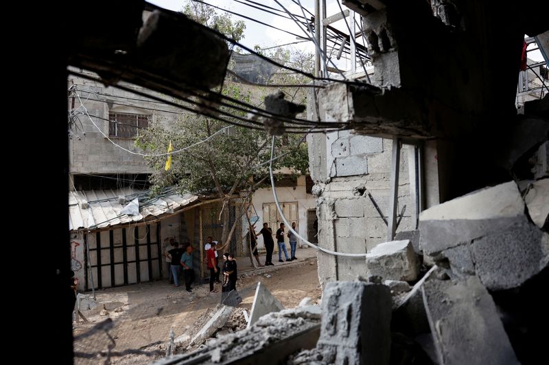 © Reuters. Palestinians stand near a damaged house following an Israeli military raid in Tulkarm in the Israeli-occupied West Bank, August 29, 2024. REUTERS/Mohammed Torokman