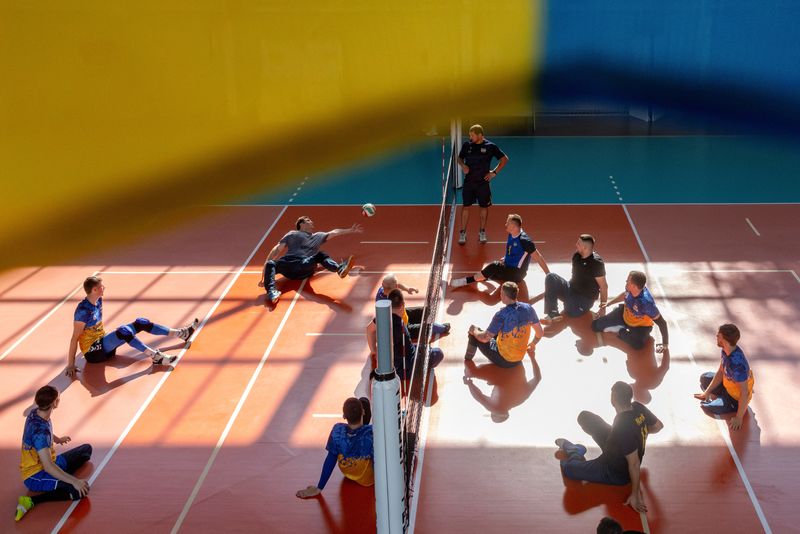 © Reuters. Former Ukrainian serviceman Yevhenii Korinets and fellow members of the sitting volleyball Paralympic Team practice at a gym in Reshetylivka, Ukraine August 7, 2024. REUTERS/Thomas Peter