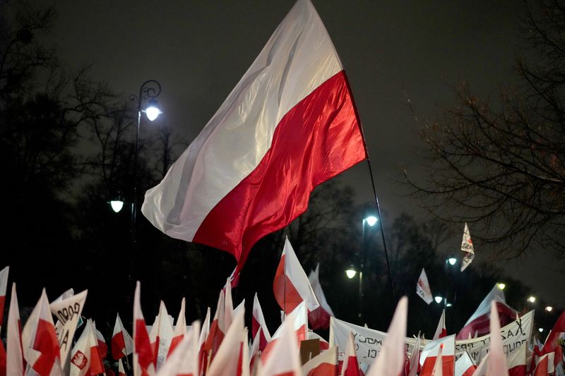 © Reuters. FILE PHOTO: A Polish flag flutters as supporters of the Law and Justice (PiS) party gather in protest against state media overhaul and arrest of former interior minister and his deputy in Warsaw, January 11, 2024. REUTERS/Aleksandra Szmigiel/File Photo