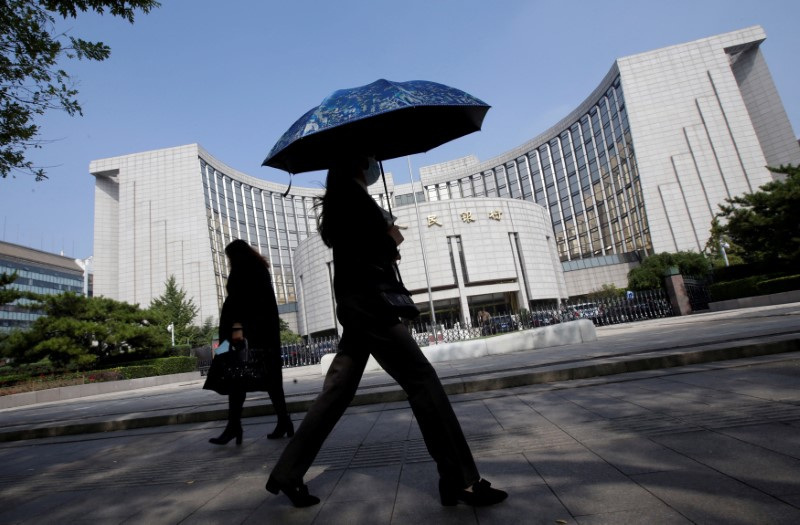 © Reuters. FILE PHOTO: People walk past the headquarters of the People's Bank of China (PBOC), the central bank, in Beijing, China September 28, 2018. REUTERS/Jason Lee/File Photo