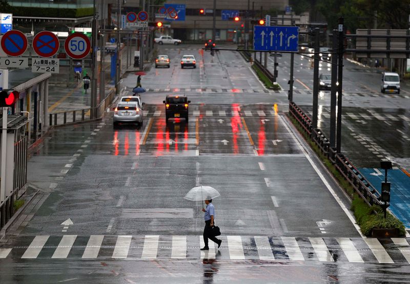 © Reuters. Bystanders holding umbrellas walk on the street in the rain and winds caused by typhoon Shanshan in Fukuoka, Japan, August 30, 2024. REUTERS/Issei Kato